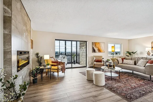 a living room with furniture wooden floor and a floor to ceiling window