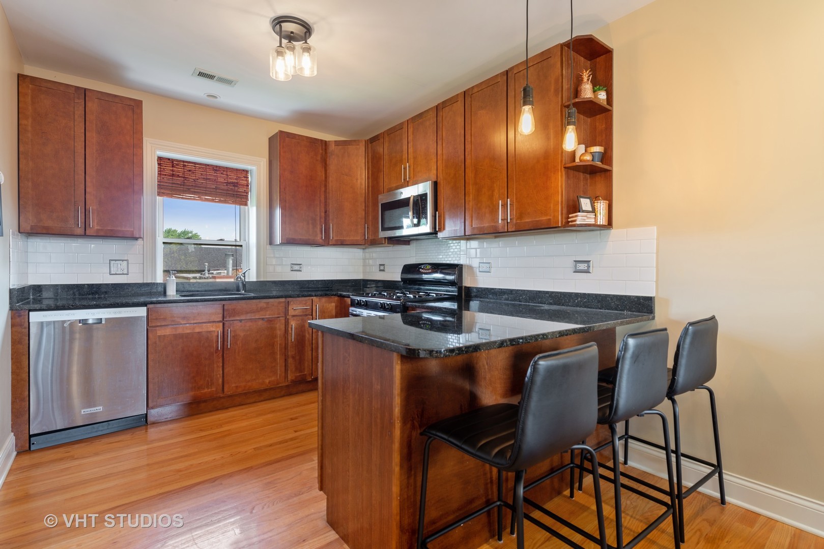 2140 West Addison Street, Unit 3D Chicago, IL 60618 - Photo 4 of 11 a kitchen with stainless steel appliances granite countertop a stove a sink dishwasher and a refrigerator with wooden floor