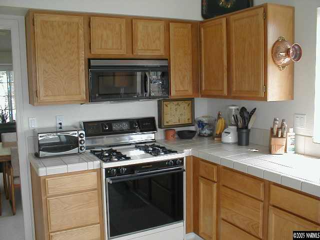 1640 Catherine Way Reno, NV 89523 - Photo 4 of 8 a kitchen with stainless steel appliances granite countertop a stove a sink and a microwave