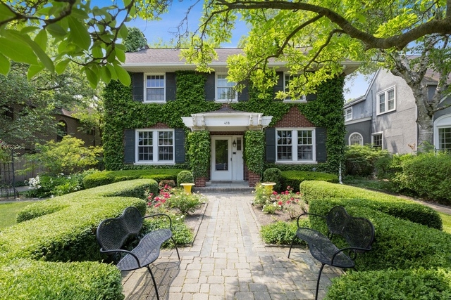a front view of a house with garden and plants