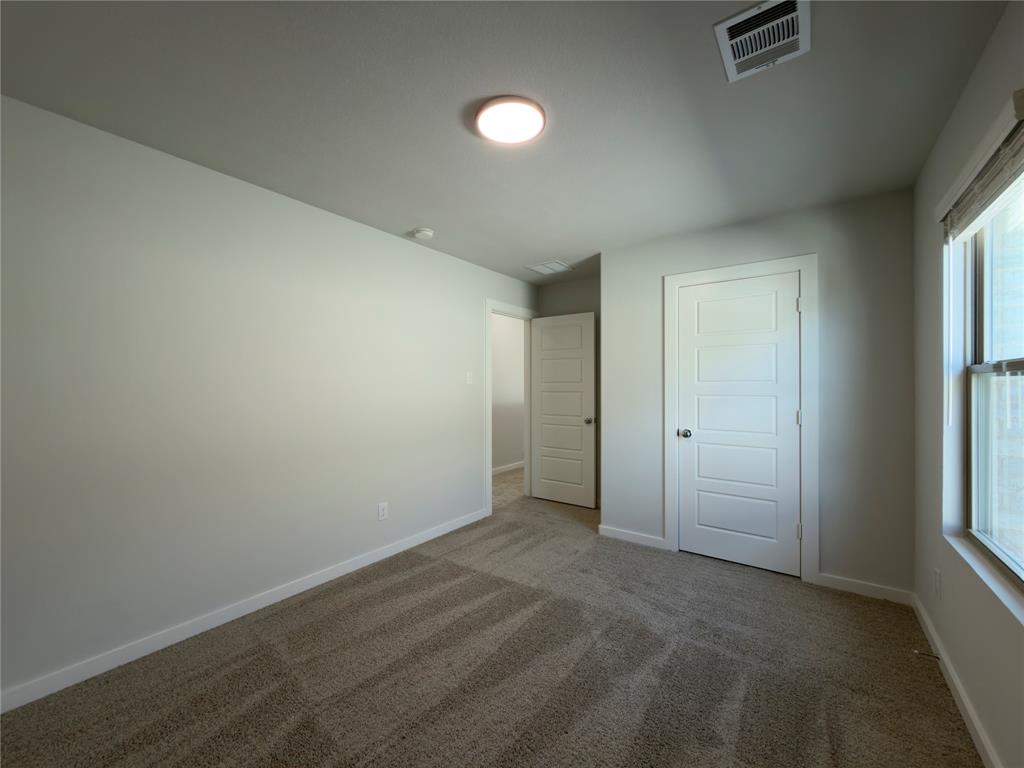 120 Millwood Road Lavon, TX 75166 - Photo 22 of 34 Carpeted room with light-toned walls, featuring a modern flush-mount ceiling light