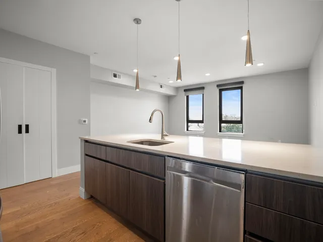 a kitchen with kitchen island a sink stainless steel appliances and cabinets