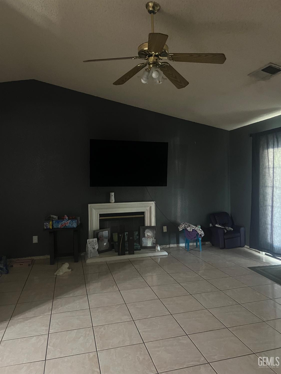Undisclosed Address Delano, CA 93215 - Photo 3 of 8 a living room with furniture a flat screen tv and a fireplace