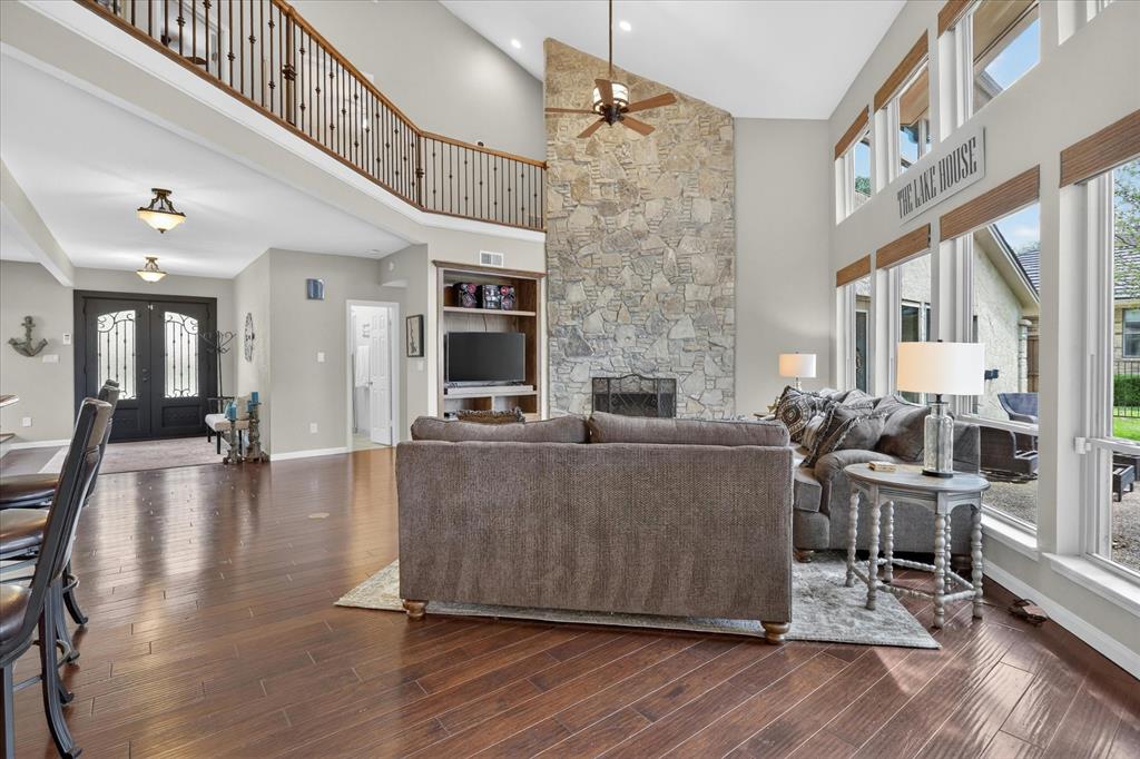 8877 Random Road Fort Worth, TX 76179 - Photo 10 of 40 Soaring vaulted ceiling with a prominent stone-clad fireplace and built-in shelving