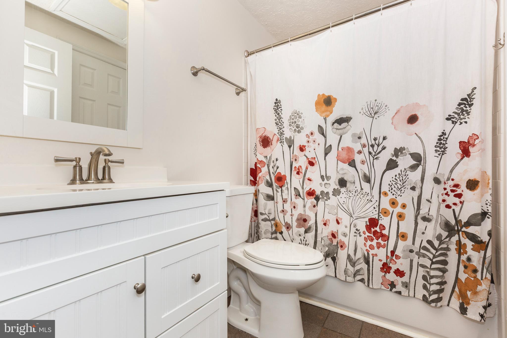 4903 Clifford Road Perry Hall, MD 21128 - Photo 21 of 30 a bathroom with a shower curtain sink and a toilet