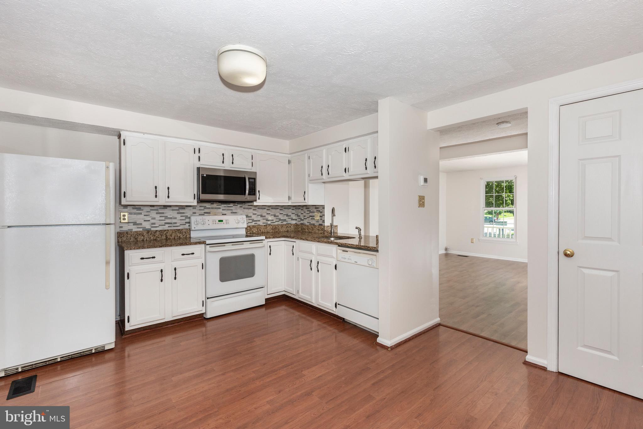 4903 Clifford Road Perry Hall, MD 21128 - Photo 8 of 30 a kitchen with stainless steel appliances white cabinets and wooden floors