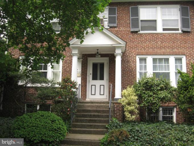 a front view of a house with trees and plants