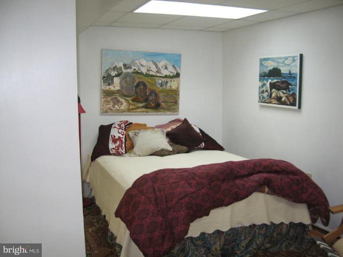 3946 Cloverhill Road Baltimore, MD 21218 - Photo 16 of 19 a bedroom with a bed and painting on the wall