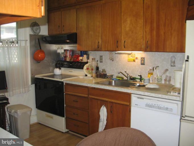 3946 Cloverhill Road Baltimore, MD 21218 - Photo 6 of 19 a kitchen with a sink a stove and cabinets