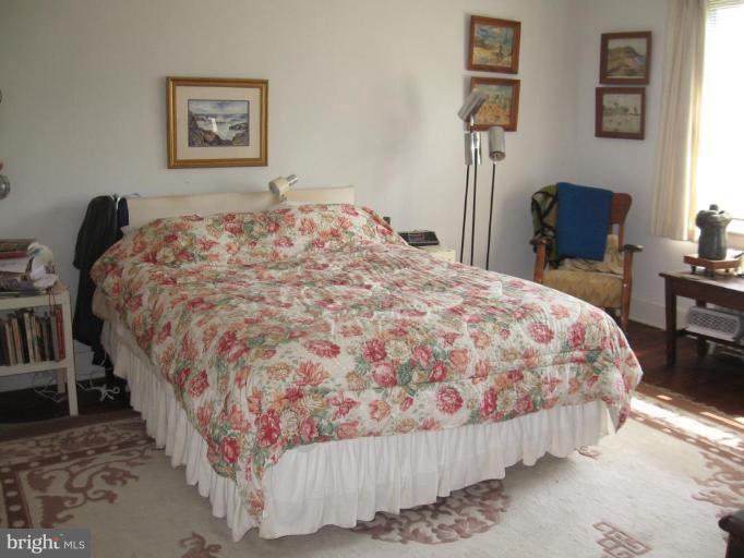 3946 Cloverhill Road Baltimore, MD 21218 - Photo 8 of 19 a bedroom with a bed and a table in it