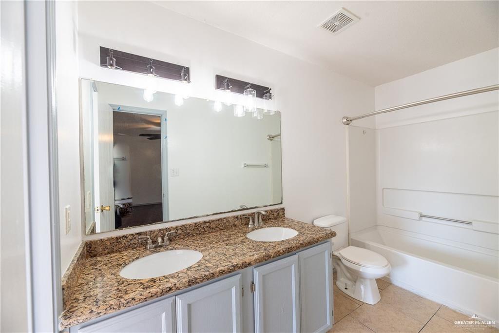 2008 West 40th Street Mission, TX 78573 - Photo 12 of 14 a bathroom with a granite countertop sink toilet and shower