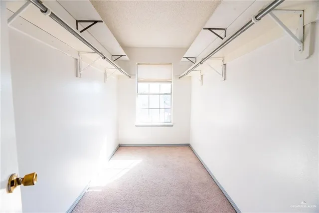 a view of a hallway with a white walls and a window