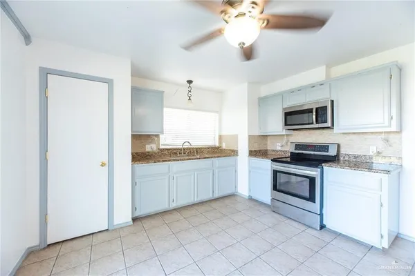a kitchen with a stove top oven and sink