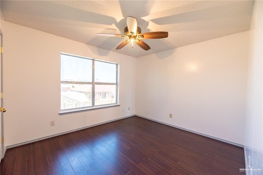 2008 West 40th Street Mission, TX 78573 - Photo 9 of 14 an empty room with wooden floor fan and windows