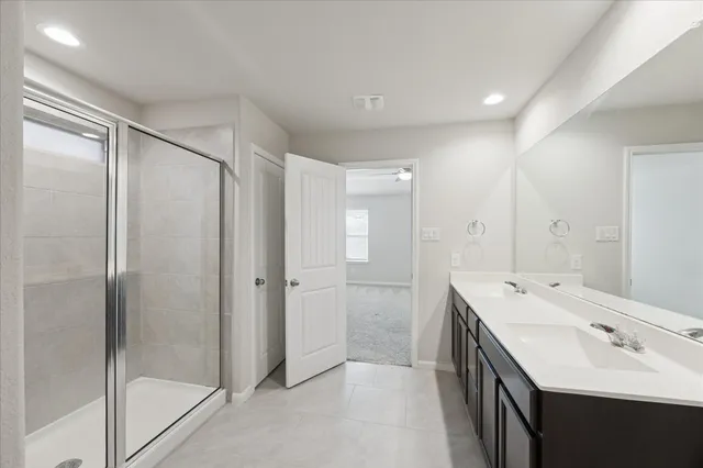 a spacious bathroom with a shower sink and mirror