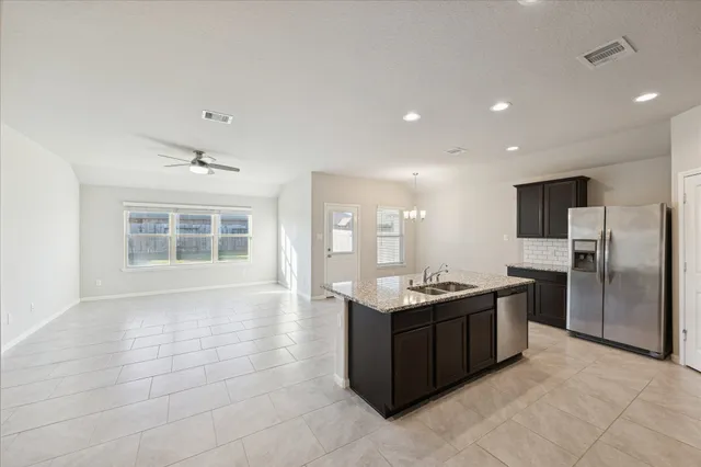 a kitchen with stainless steel appliances granite countertop a sink and a stove
