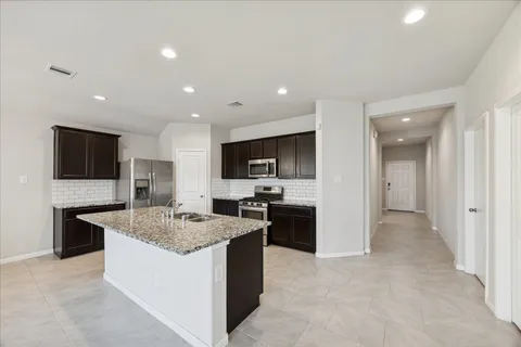 a kitchen with stainless steel appliances granite countertop a sink stove and refrigerator