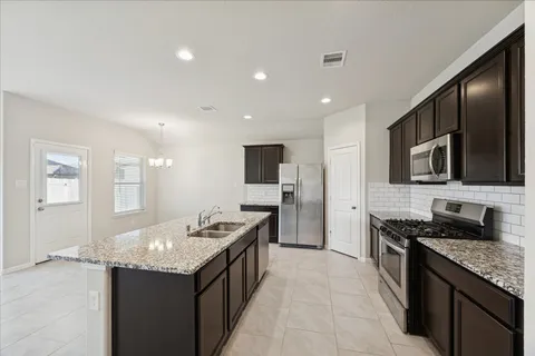 a kitchen with stainless steel appliances granite countertop a sink stove and refrigerator