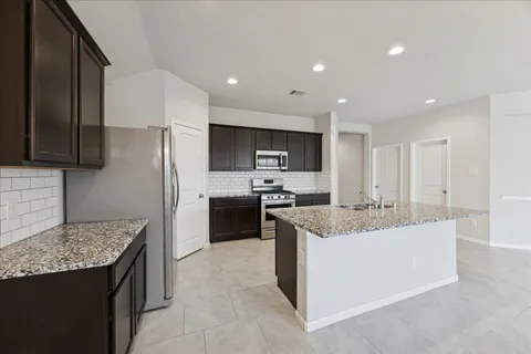 a kitchen with stainless steel appliances granite countertop a sink stove and refrigerator