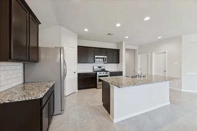 a kitchen with stainless steel appliances granite countertop a sink stove and refrigerator