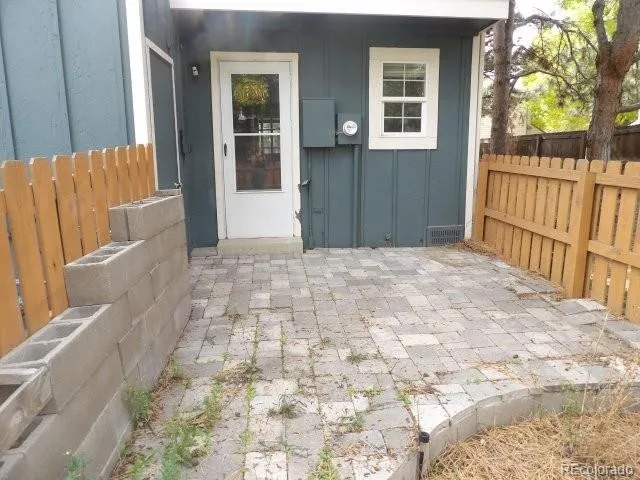 a view of backyard with large trees and wooden fence