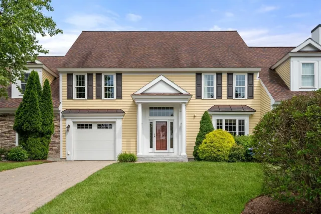 a front view of a house with a yard and trees