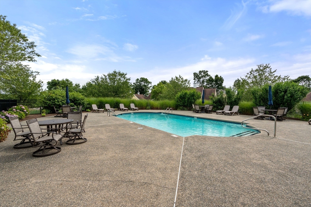 7 English Cmns, Unit 7 Topsfield, MA 01983 - Photo 36 of 36 a view of a swimming pool with a table and chairs under an umbrella