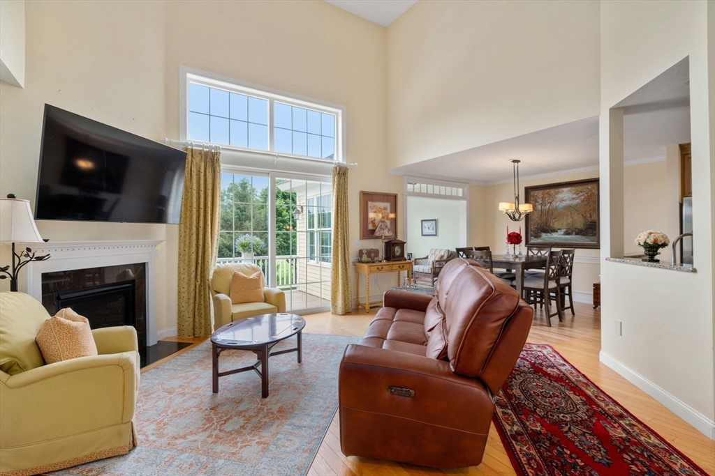 7 English Cmns, Unit 7 Topsfield, MA 01983 - Photo 4 of 36 a living room with furniture a fireplace and a flat screen tv