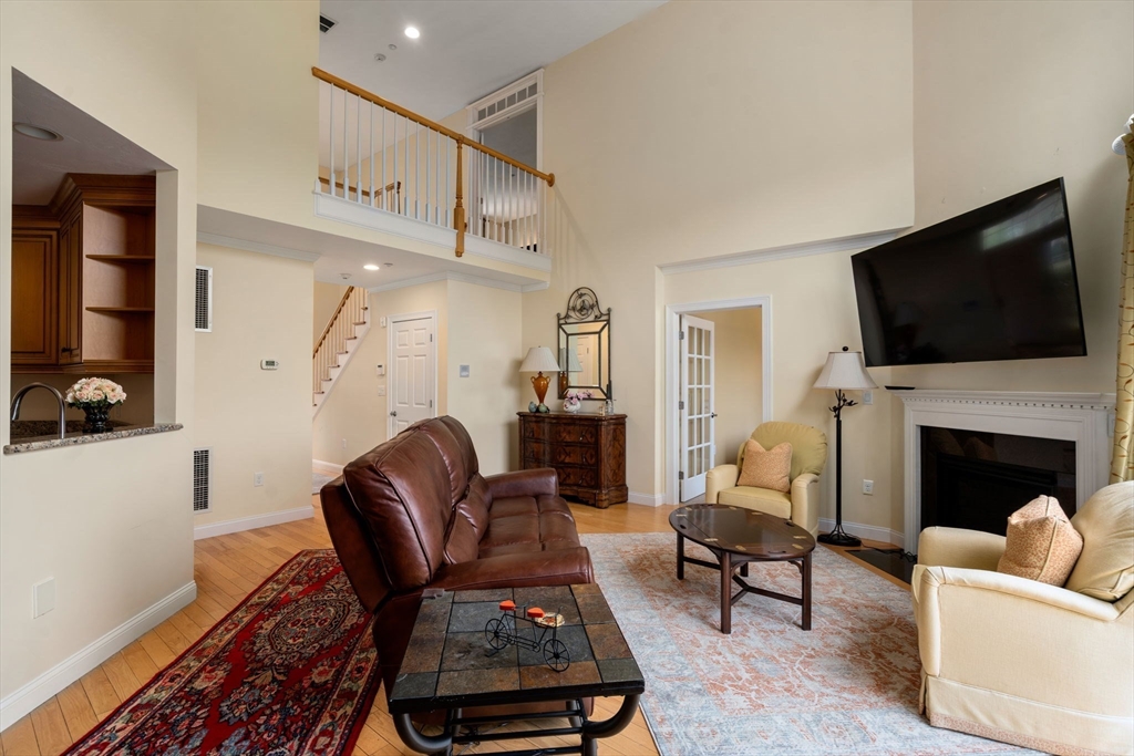 7 English Cmns, Unit 7 Topsfield, MA 01983 - Photo 5 of 36 a living room with furniture a flat screen tv and a fireplace