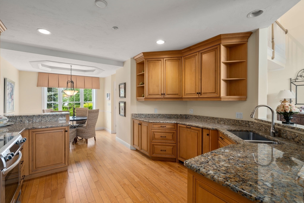 7 English Cmns, Unit 7 Topsfield, MA 01983 - Photo 8 of 36 a kitchen with kitchen island granite countertop wooden floors and white appliances