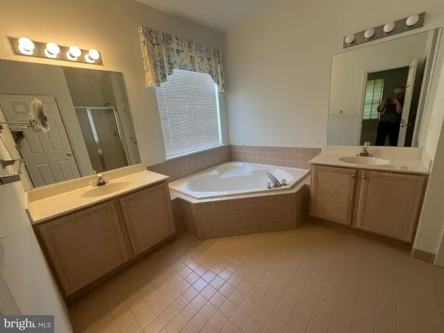 a bathroom with a tub sink and mirror
