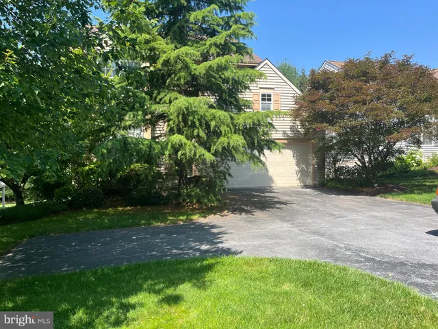 a view of a yard in front of a house with large trees