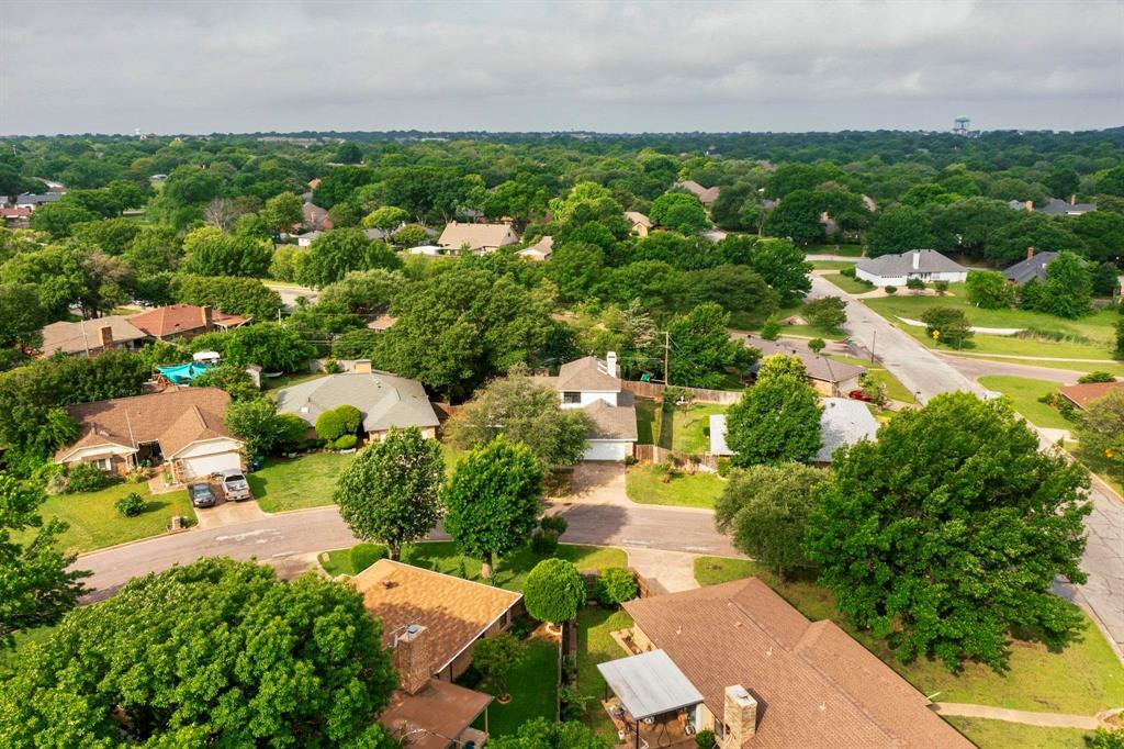 3965 Singleleaf Lane Fort Worth, TX 76133 - Photo 38 of 39 Residential neighborhood featuring mature tree canopy, varied single-family homes, paved streets, and a distant water tower