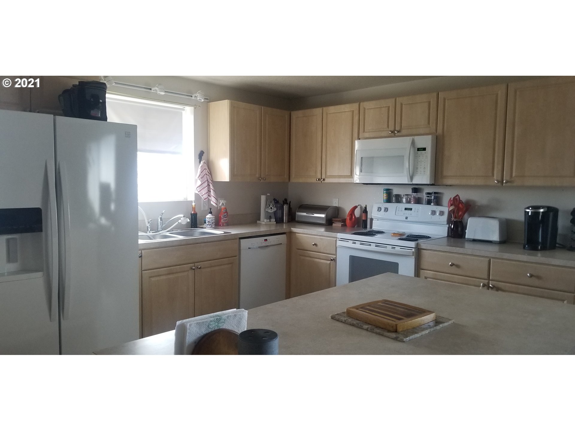335 Southeast 3rd Street Irrigon, OR 97844 - Photo 5 of 29 a kitchen with a refrigerator a sink a stove and cabinets