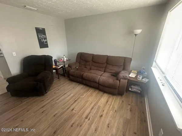 a living room with furniture and a wooden floor