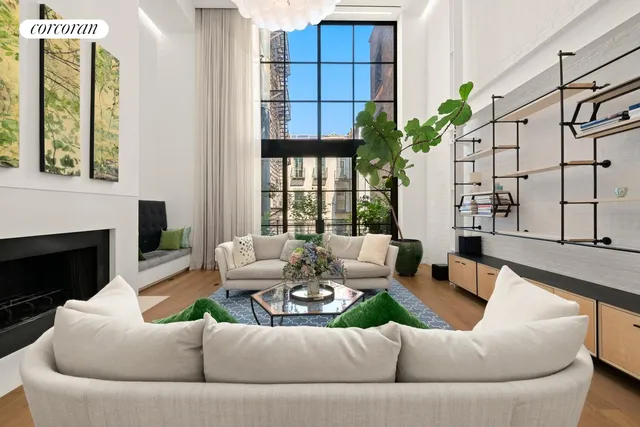 a living room with furniture fireplace and a large window