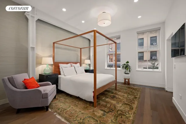 a bedroom with furniture and large windows