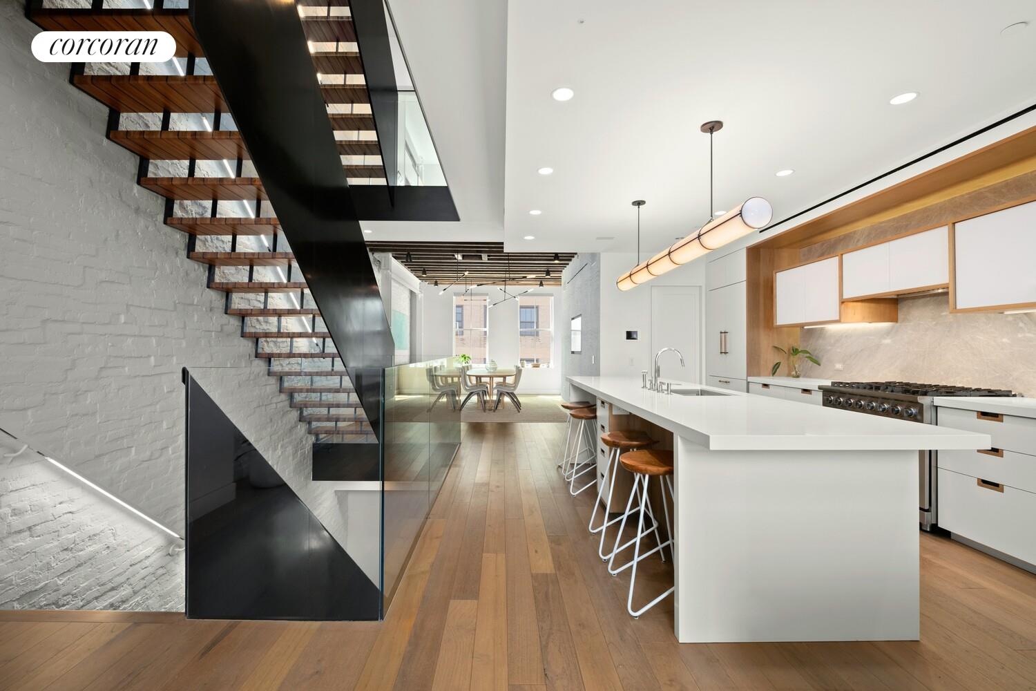 19 Jay Street Manhattan, NY 10013 - Photo 7 of 32 a kitchen with stainless steel appliances granite countertop a stove a refrigerator and a dining table with wooden floor