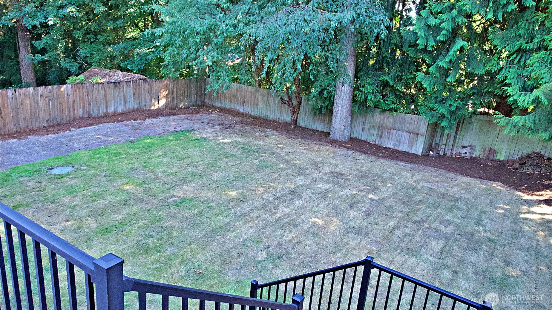 16 234th Place Southeast Bothell, WA 98021 - Photo 34 of 36 a view of a backyard with large trees and wooden fence