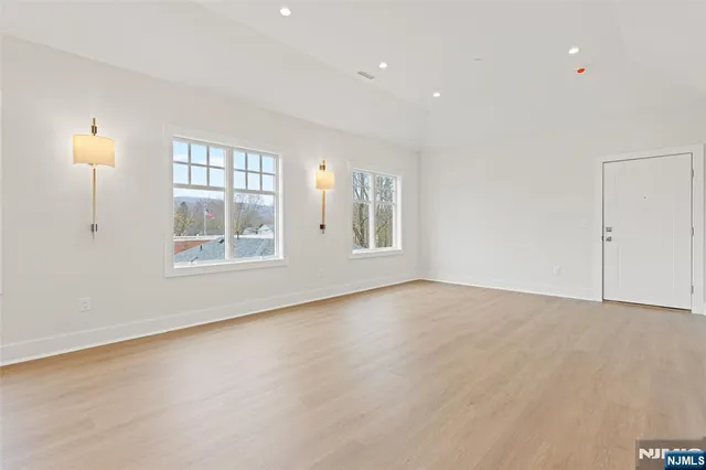 an empty room with windows and cabinet