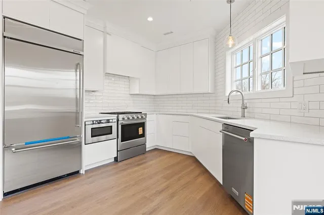 a kitchen with a sink stainless steel appliances and cabinets