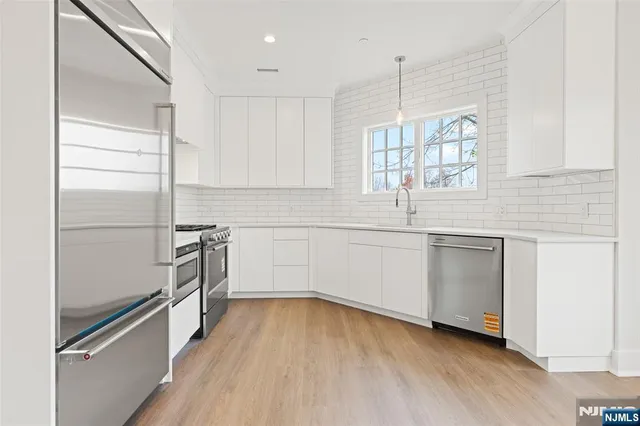 a kitchen with white cabinets and white appliances