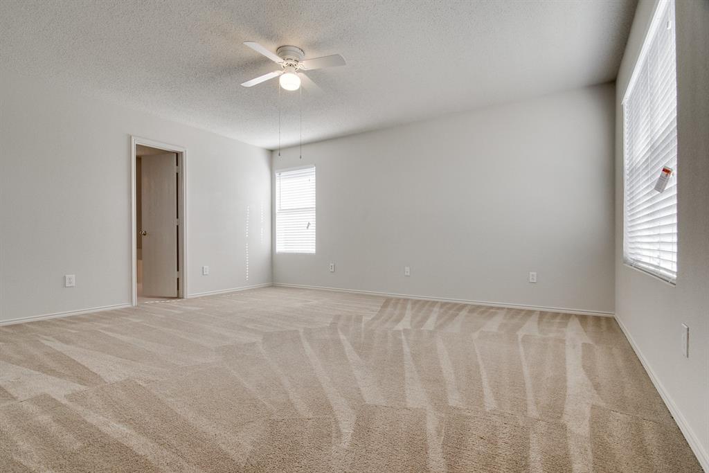 8211 Leaning Oak Court Arlington, TX 76002 - Photo 17 of 26 Unfurnished room with light colored carpet, a textured ceiling, and ceiling fan