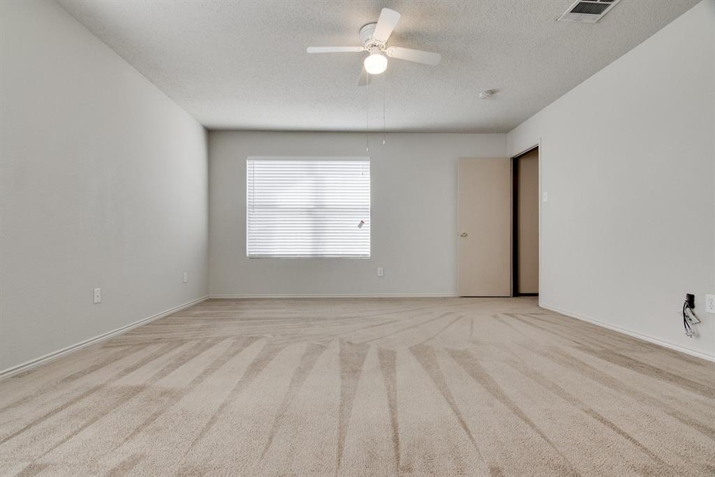8211 Leaning Oak Court Arlington, TX 76002 - Photo 18 of 26 Spare room featuring light colored carpet, a textured ceiling, and a ceiling fan