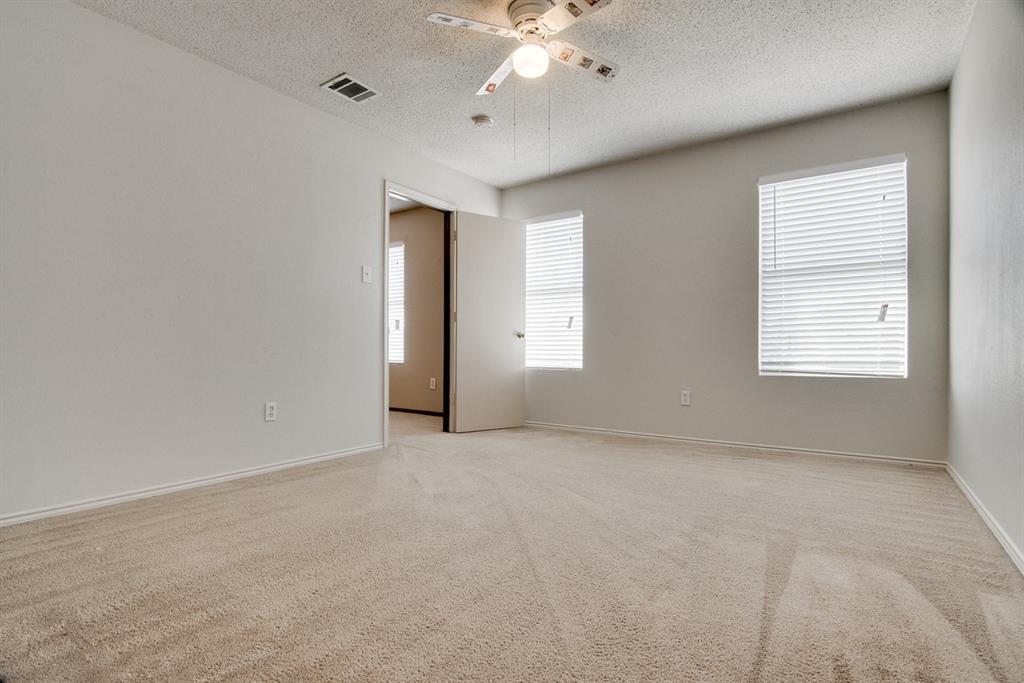 8211 Leaning Oak Court Arlington, TX 76002 - Photo 20 of 26 Empty room featuring light colored carpet, healthy amount of natural light, a textured ceiling, and a ceiling fan