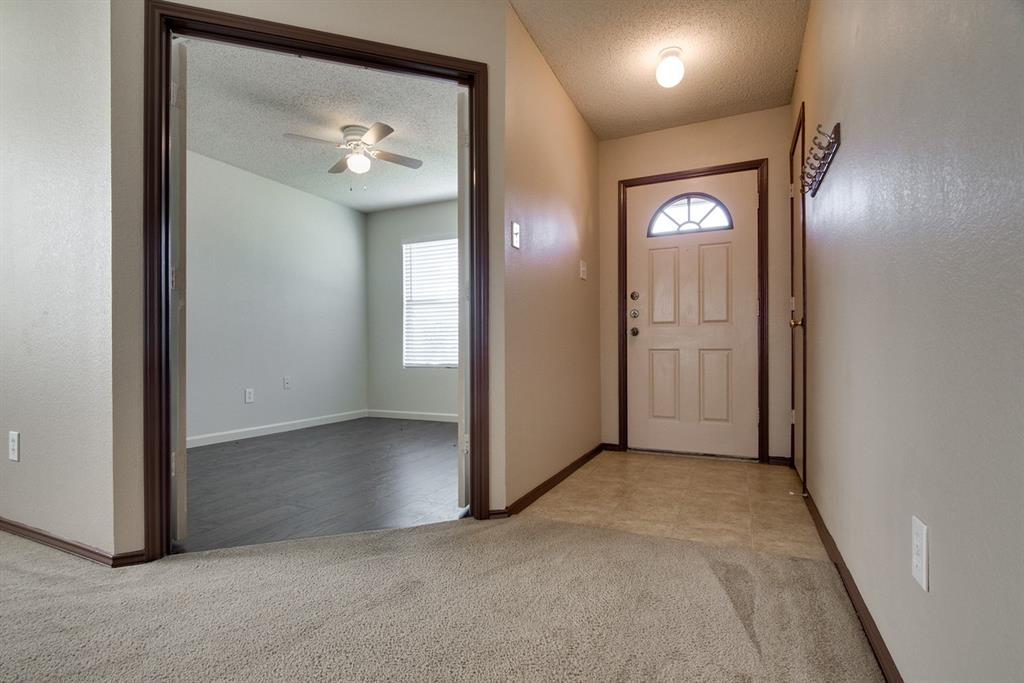 8211 Leaning Oak Court Arlington, TX 76002 - Photo 4 of 26 Foyer featuring light carpet, a textured ceiling, a ceiling fan, and light tile patterned floors