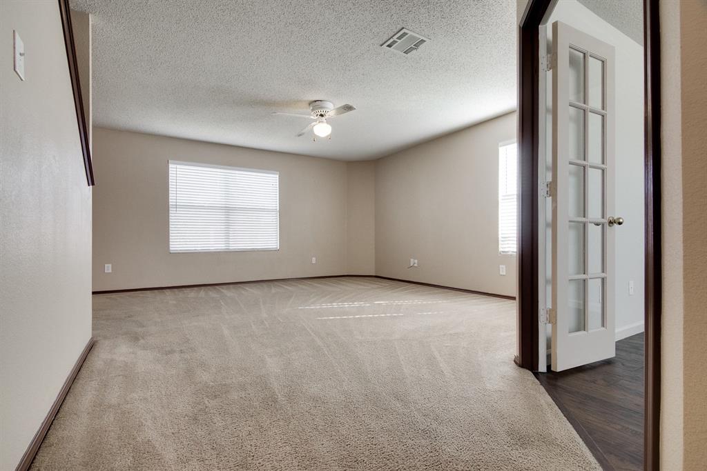 8211 Leaning Oak Court Arlington, TX 76002 - Photo 5 of 26 Carpeted spare room featuring a textured ceiling and ceiling fan