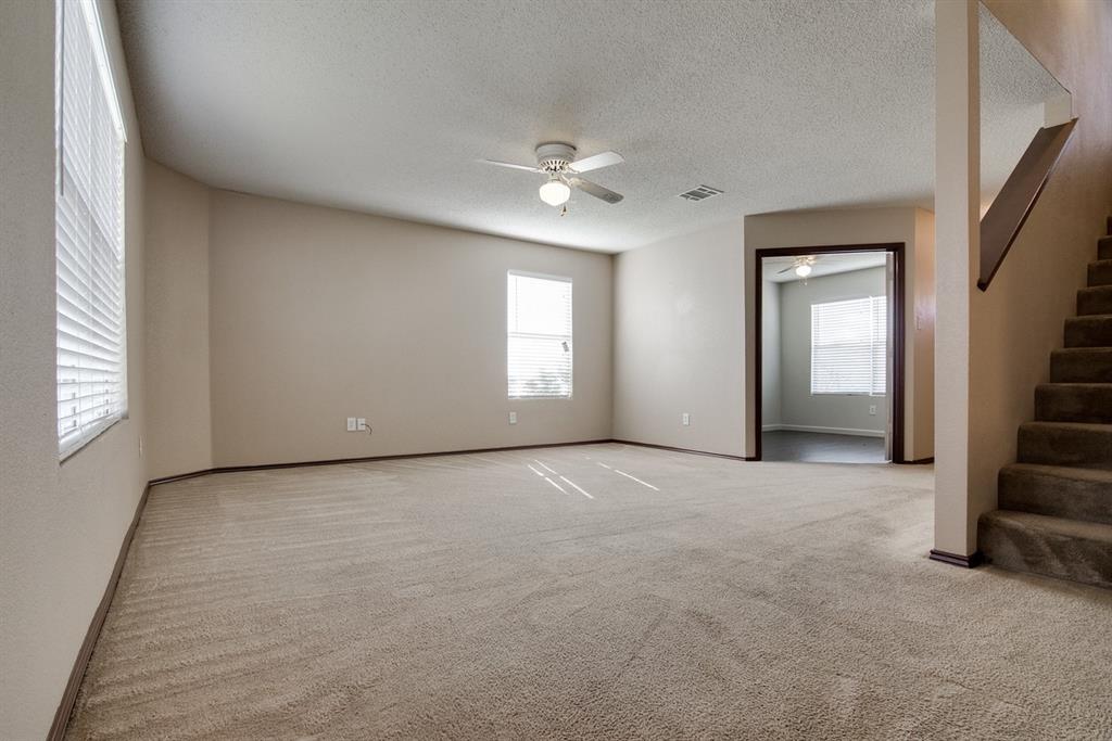 8211 Leaning Oak Court Arlington, TX 76002 - Photo 8 of 26 Carpeted spare room with stairs, a textured ceiling, and ceiling fan