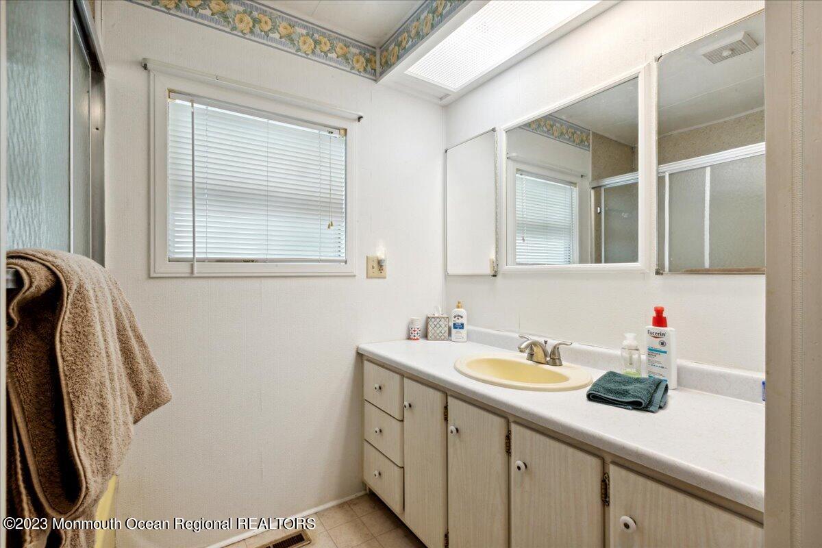 422 Roberts Road Toms River, NJ 08755 - Photo 17 of 18 a bathroom with a sink a mirror and a shower