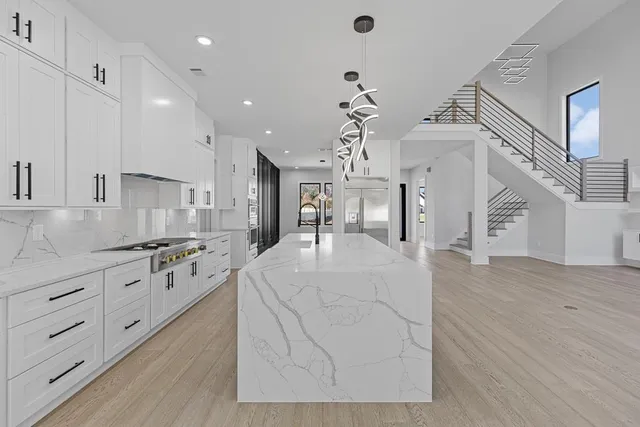 a large kitchen with stainless steel appliances granite countertop a stove and a sink